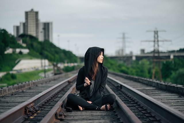 線路のうえに座る女性